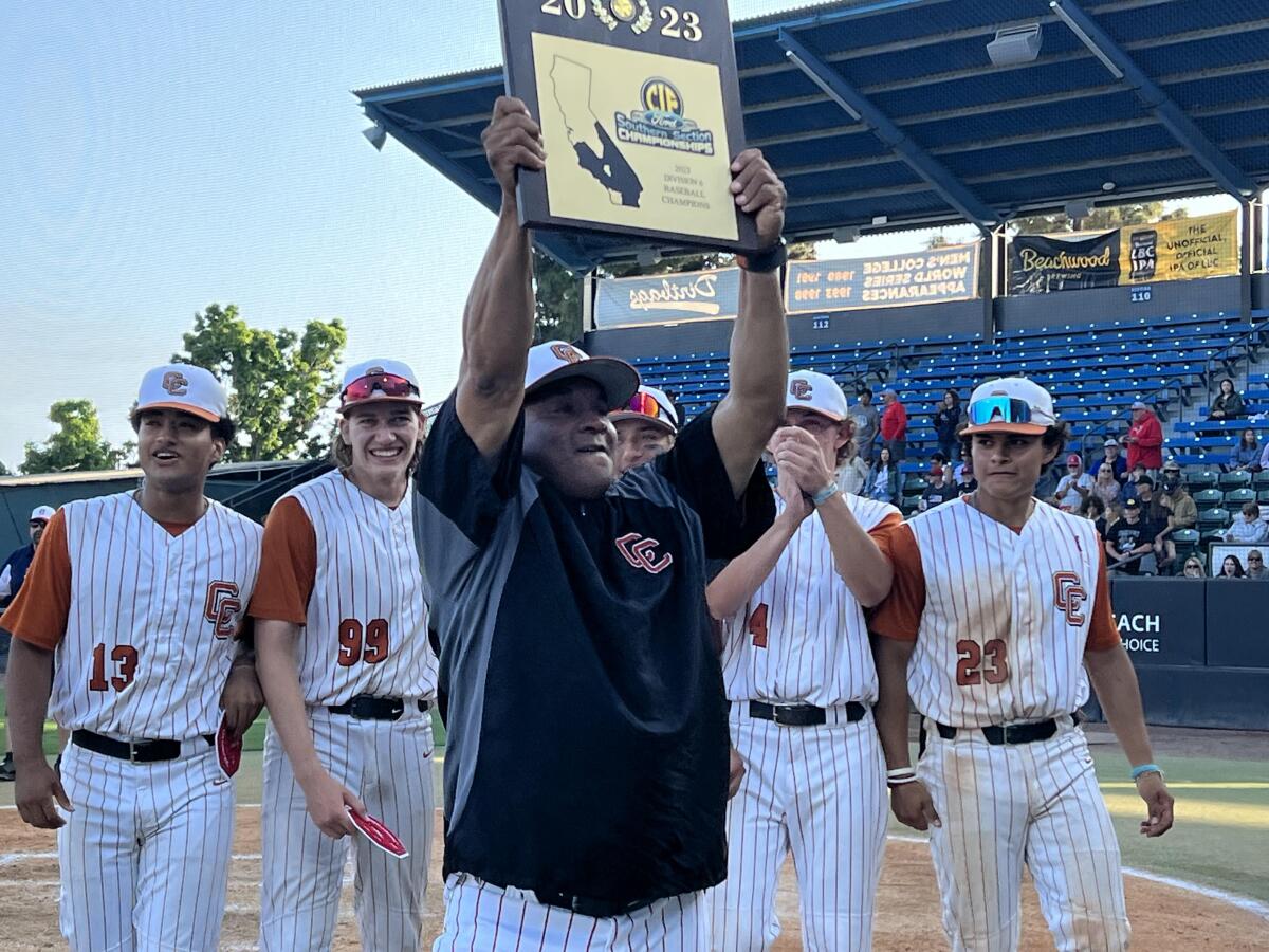 Coach Darrell Davis of Castaic raises the Division 6 championship plaque after his team's 7-0 win over Hesperia Christian.
