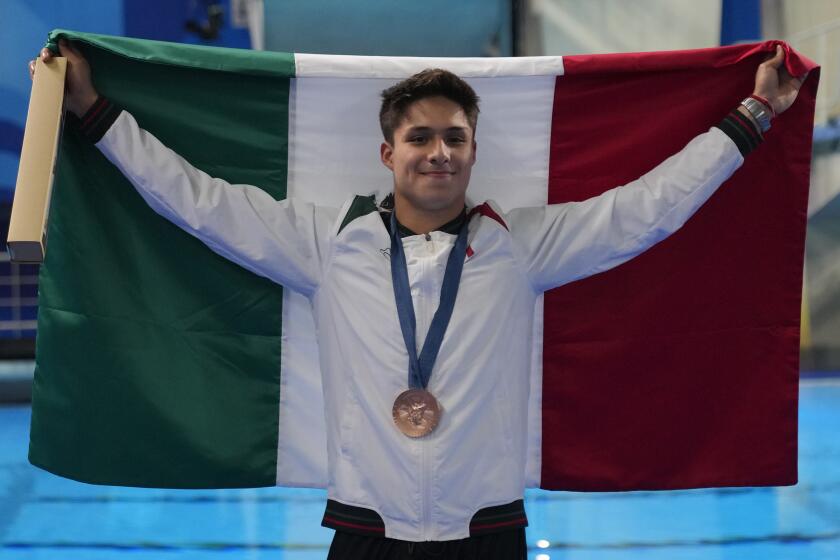 El mexicano Osmar Olvera carga la bandera de su país luego de capturar la medalla de bronce en el trampolín de tres metros de los Juegos Olímpicos del 2024 el jueves 8 de agosto del 2024, en Saint-Denis, Francia. (AP Foto/Dar Yasin)