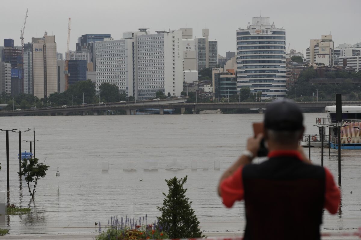The display of South Korea's capital Seoul logo is almost submerged due to heavy rain at a park near the Han River in Seoul, South Korea, Thursday, Aug. 6, 2020. Torrential rains continuously pounded South Korea on Thursday, prompting authorities to close parts of highways and issue a rare flood alert near a key river bridge in Seoul. (AP Photo/Lee Jin-man)