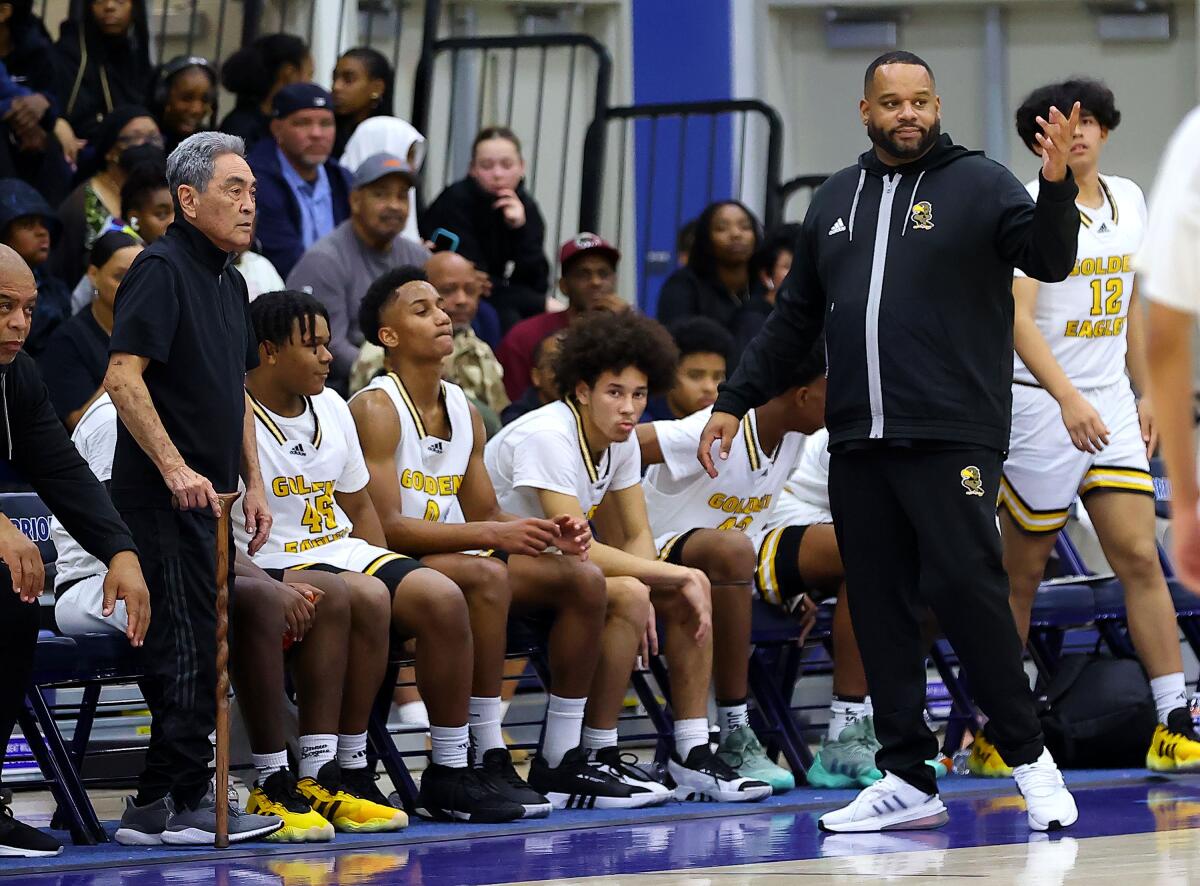 King/Drew basketball coach Lloyd Webster (right) gives instruction to players on the court.