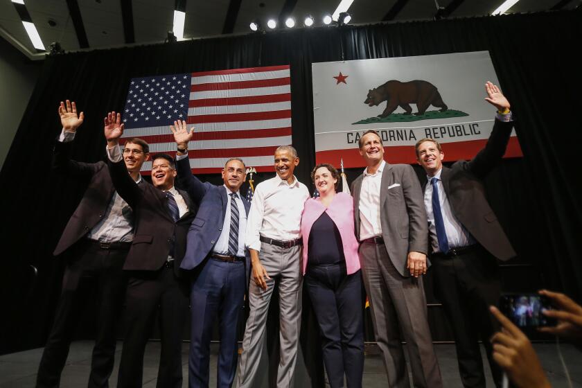 Former President Barack Obama, center, with congressional candidates, from left, Josh Harder, TJ Cox, Gil Cisneros, Katie Porter, Harley Rouda and Mike Levin wave to supporters as Obama campaigns in support of California congressional candidates, Saturday, Sept. 8, 2018, in Anaheim, Calif. (AP Photo/Ringo H.W. Chiu)