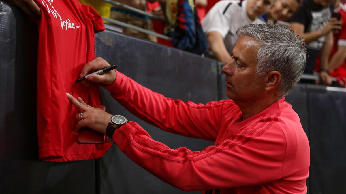 Manchester United manager Jose Mourinho signs an autograph prior to an International Champions Cup game against Club America on July 19 in Glendale, Arizona.