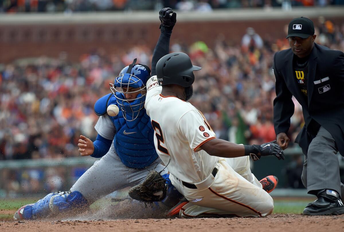 Giants outfielder Denard Span beats the throw to Dodgers catcher Austin Barnes to score on a two-run double from Joe Panik during an April 10 game at AT&T Park in San Francisco.