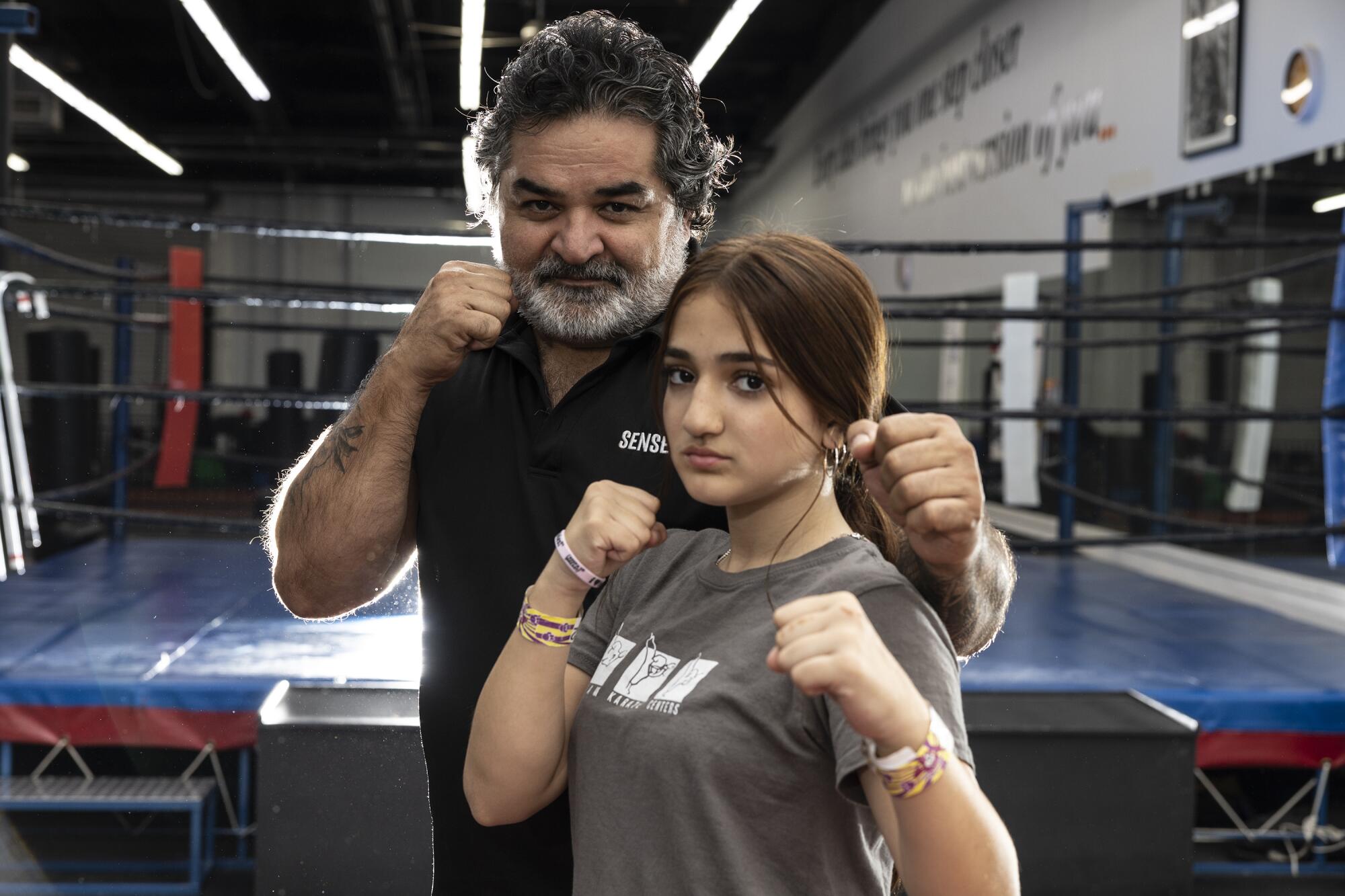 Fariborz Azhakh and his daughter Katana pose with their fists up.