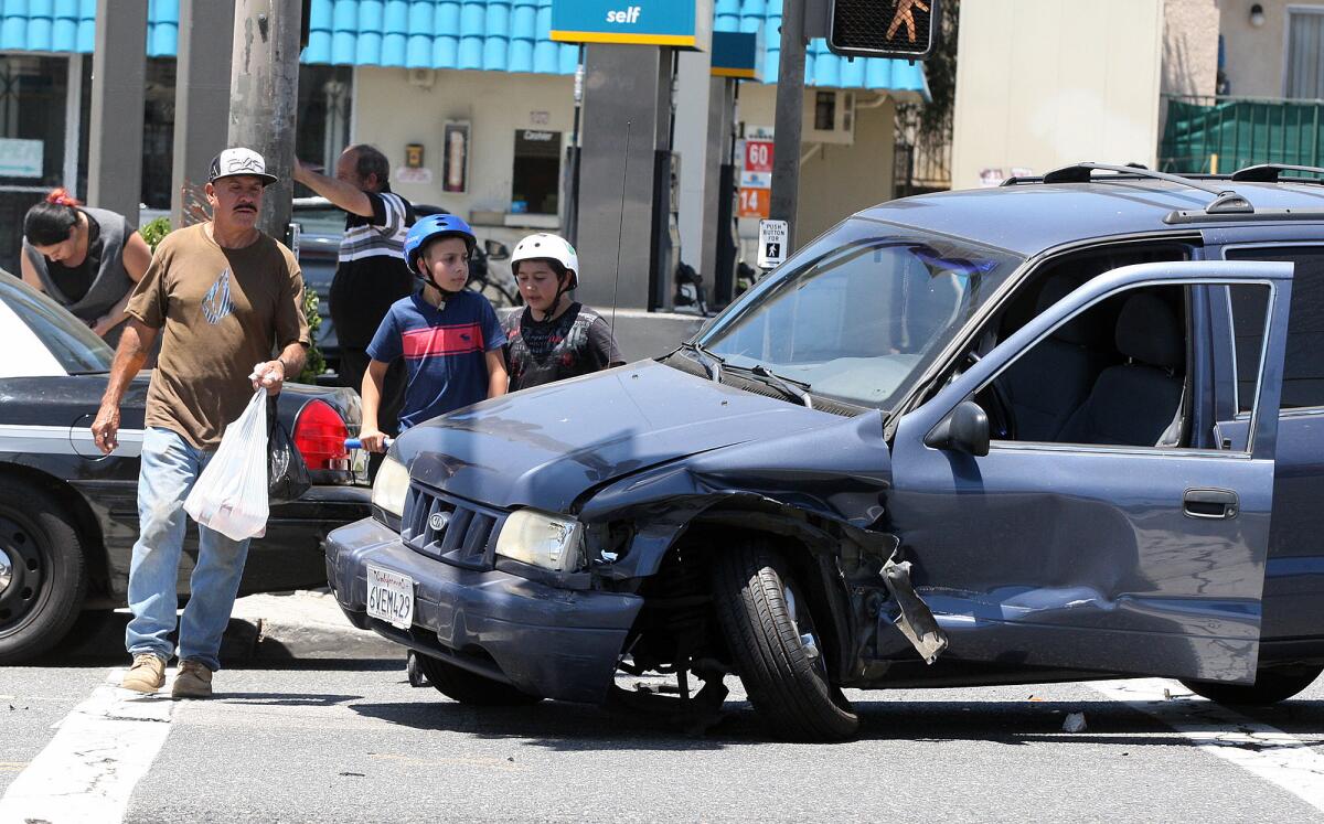 Pedestrians, as well as motorists, make their way around and through the scene of a crash at the intersection of Colorado Blvd. and Pacific Avenue in Glendale on Thursday, June 19, 2014.