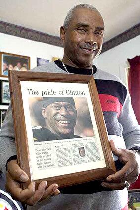 HOMETOWN HER0: Willie Parker Sr. shows off his favorite memento from the wall dedicated to son's achievements.