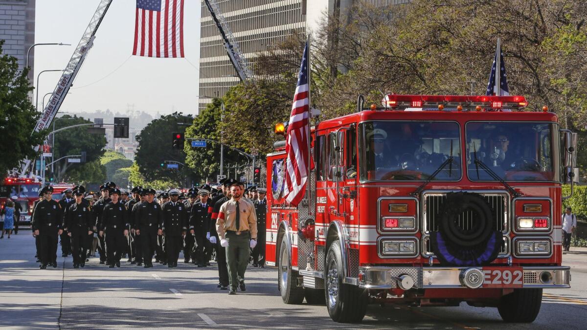 An LAFD fire truck carries the coffin of fallen firefighter Kelly Wong up Temple Street, enroute to his memorial service in June 2017.