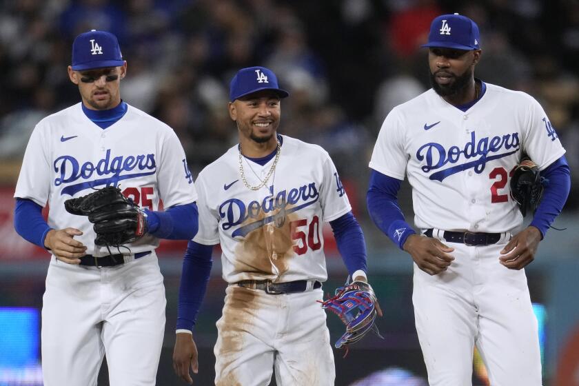 Los Angeles Dodgers second baseman Mookie Betts, center, walks back to the dugout with right fielder Jason Heyward.