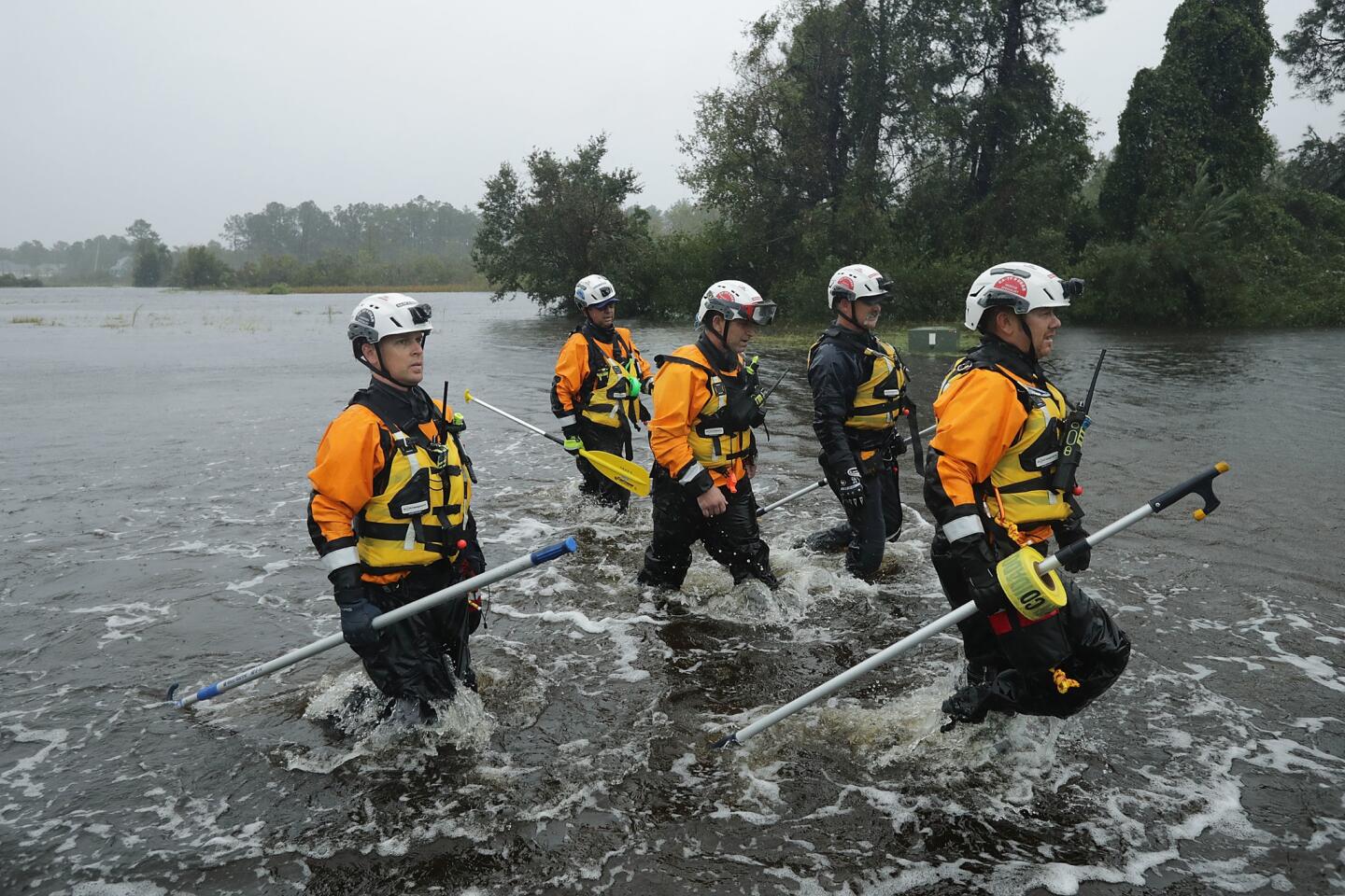 Members of the FEMA Urban Search and Rescue Task Force 4 from Oakland search a flooded neighborhood for evacuees in Fairfield Harbour, N.C.