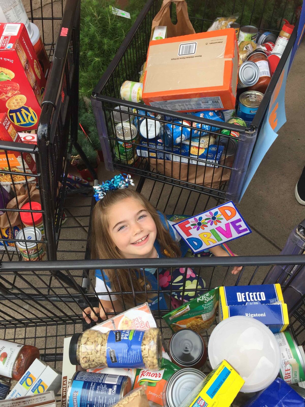 A Daisy with the troop's food drive haul.