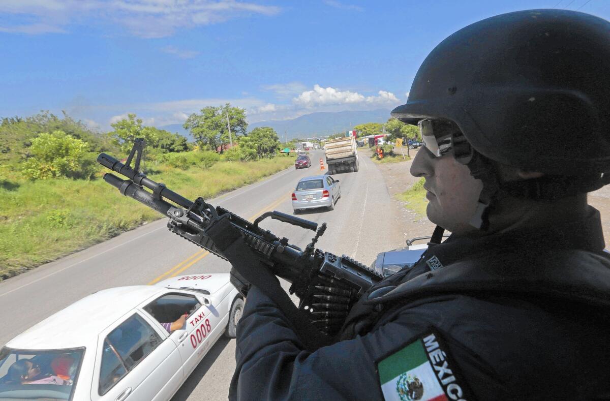 A federal police officer keeps watch at a checkpoint in Iguala, Mexico.