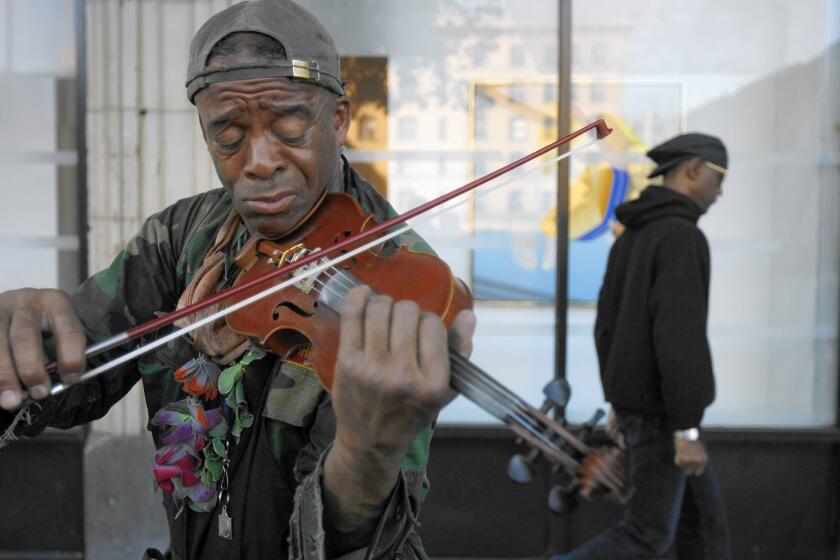 Nathaniel Ayers plays the violin in downtown Los Angeles in 2008. Friday, he was back on skid row to attend a concert.