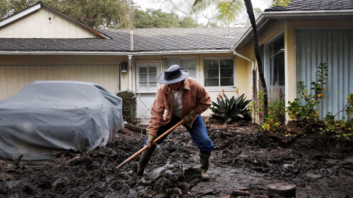 Mark Vance shovels mud away from his house on Olive Mill Road in Montecito, California.