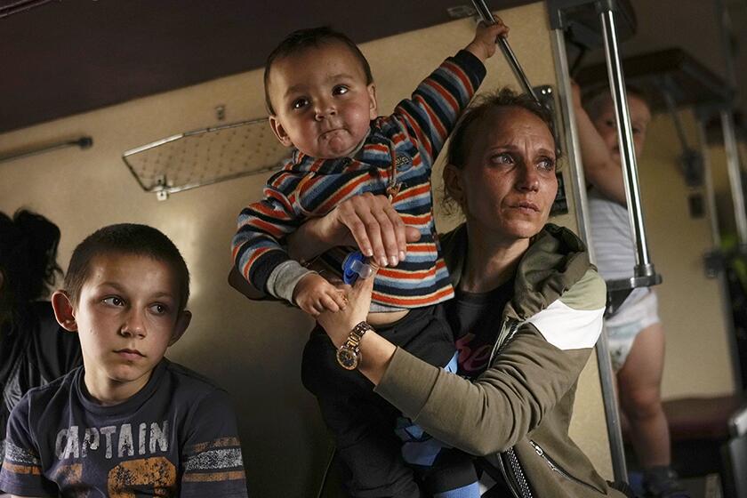 Yana Skakova and her two sons on an evacuation train in Pokrovsk, Ukraine, on Saturday.