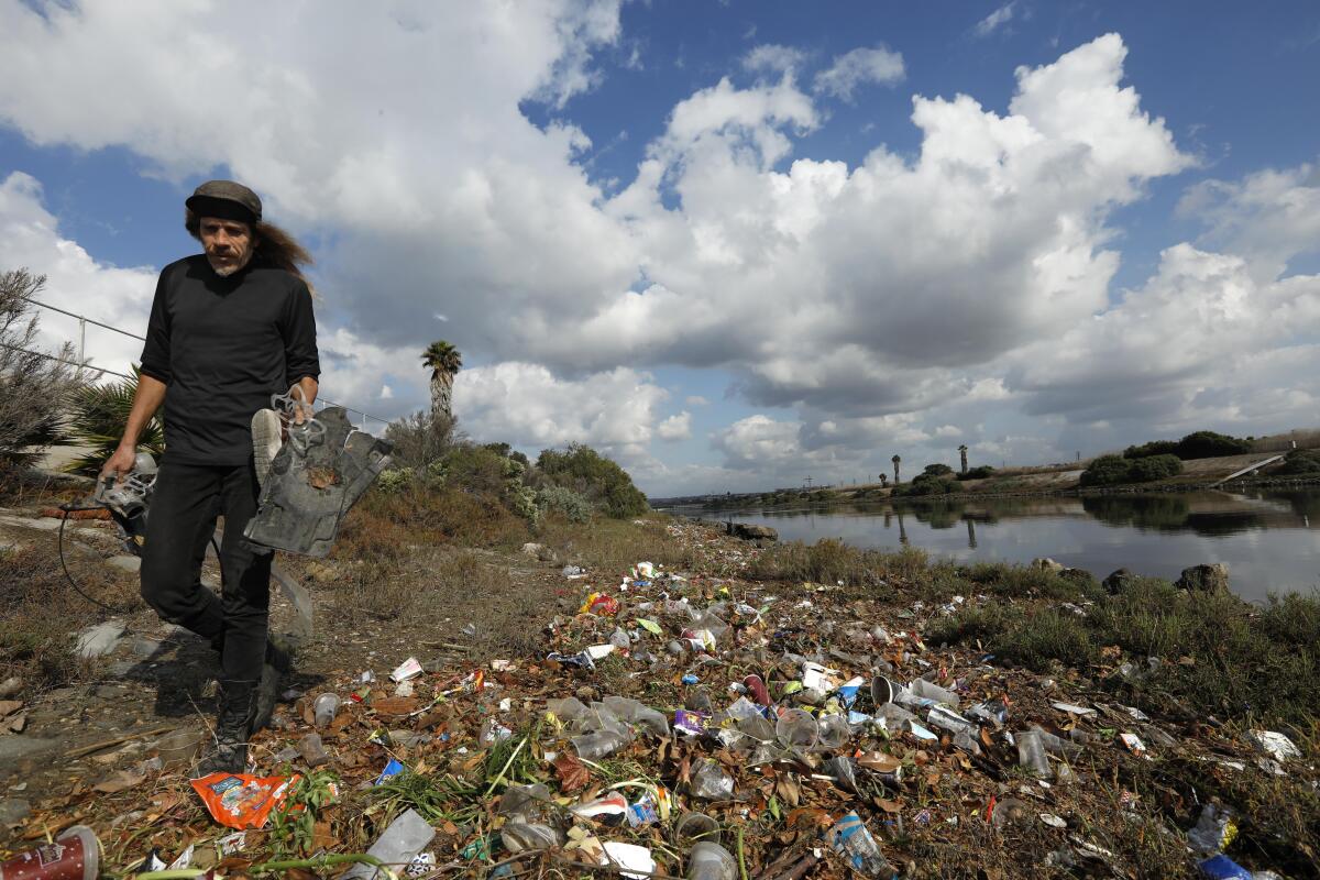 Josey Peters collects trash along Ballona Creek. 