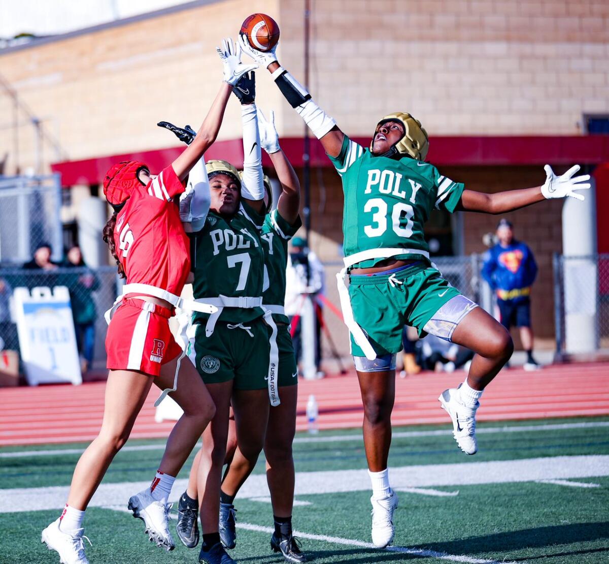 Long Beach Poly players battle for the ball in seven on seven girls' flag football tournament game.