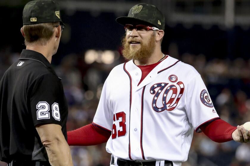Washington Nationals relief pitcher Sean Doolittle speaks with umpire Jim Wolf (28) after Chicago Cubs manager Joe Maddon argues over his pitching mechanics during the ninth inning of a baseball game, Saturday, May 18, 2019, in Washington. The Washington Nationals won 5-2. (AP Photo/Andrew Harnik)