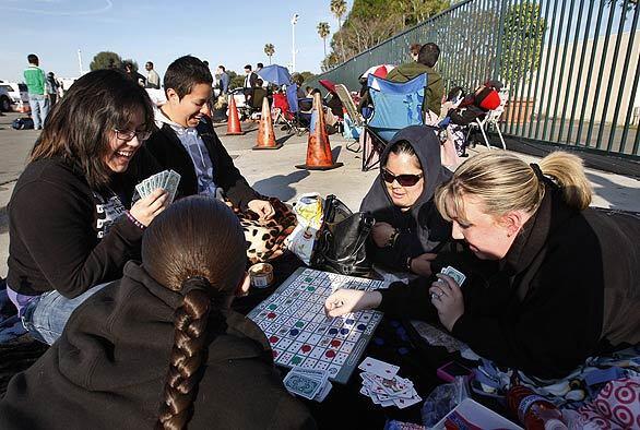 While waiting to get good seats at an Orange County town hall meeting with the president, a game of cards helps pass the time for, from left, Sara Carrion of Whittier, Monica Salas of Norwalk, Alva Garcia of Whittier, Andrea Morales of San Pedro and Carrie Biely of Long Beach.