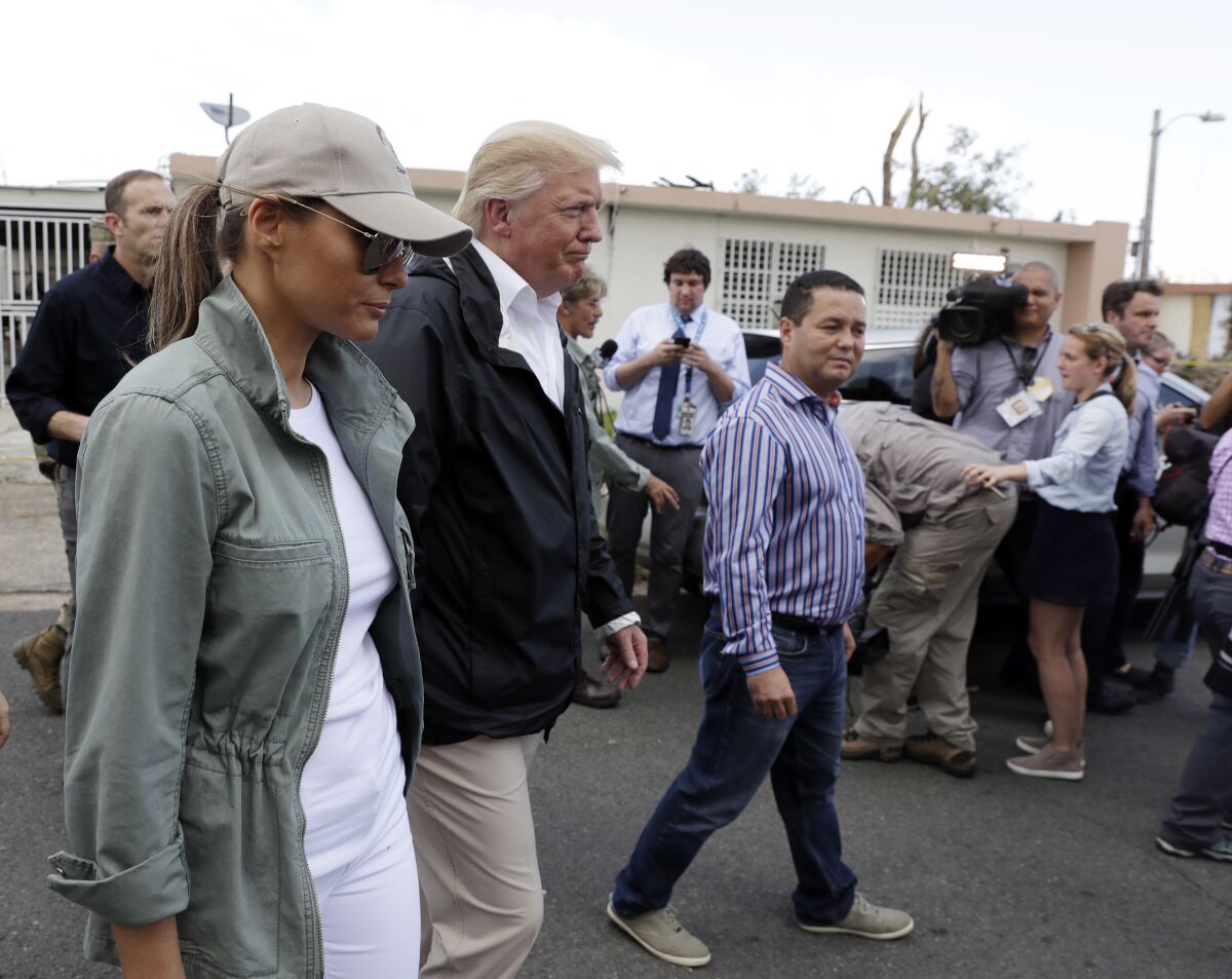 FILE - Mayor Angel Perez Otero, right center, accompanies President Donald Trump and first lady Melania Trump on a walking tour to survey hurricane damage and recovery efforts in Guaynabo, Puerto Rico, Oct. 3, 2017. Federal agents arrested Perez Otero on corruption charges Thursday, Dec. 9, 2021. He is accused of regularly accepting payments of $5,000 in exchange for awarding contracts to the owner of a construction company. (AP Photo/Evan Vucci, File)