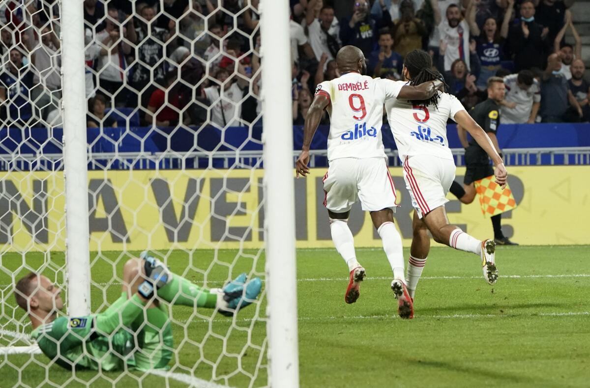 Lyon's Jason Denayer, right, celebrates with Moussa Dembele after scoring his side's second goal during the French League One soccer match between Strasbourg RCSA and Olympique Lyonnais at the Groupama stadium in Lyon, France, Sunday, Sept. 12, 2021. (AP Photo/Laurent Cipriani)