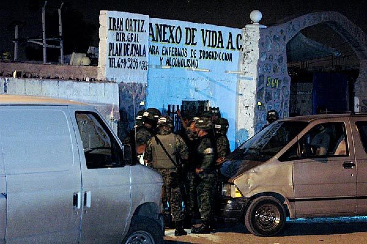 Soldiers stand outside the drug rehabilitation center where, according to local media, at least 10 people were killed after unidentified gunmen stormed it. Five other people were killed early today in Ciudad Juarez when gunmen attacked the Coco Bongo nightclub as customers were deep in celebration of Mexican Independence Day.