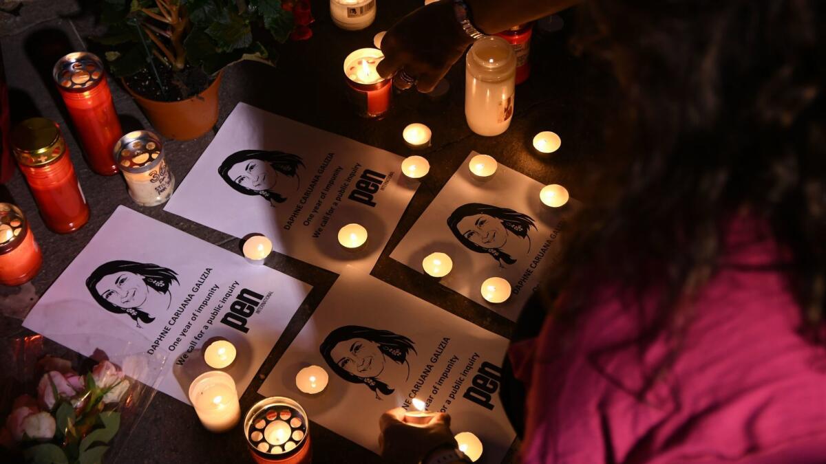 People take part in a vigil to commemorate slain investigative journalist Daphne Caruana Galizia outside the courthouse in Valletta, Malta.