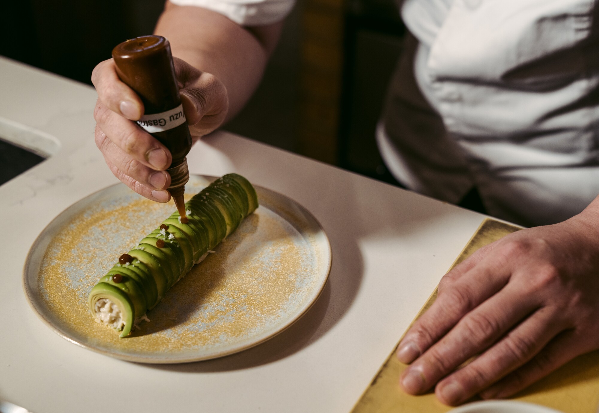 A chef puts sauce on a dish