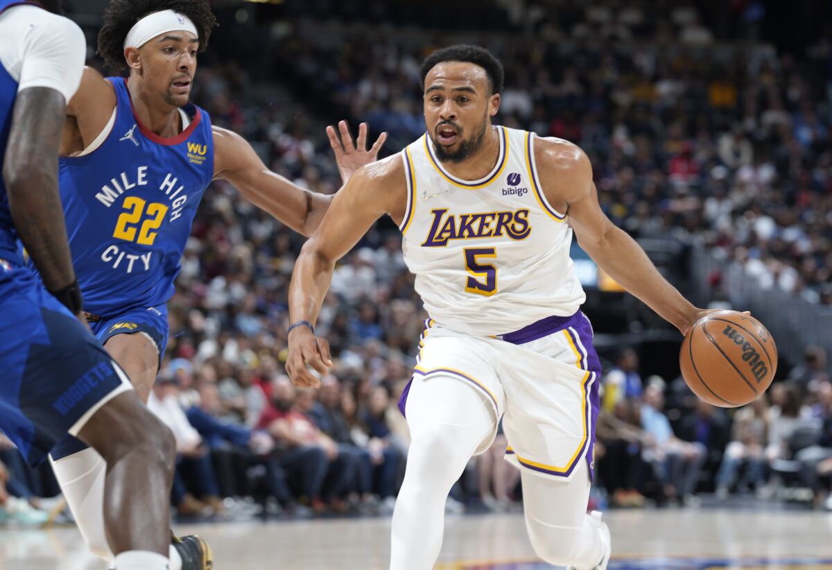 Los Angeles Lakers guard Talen Horton-Tucker, right, drives past Denver Nuggets forward Zeke Nnaji.