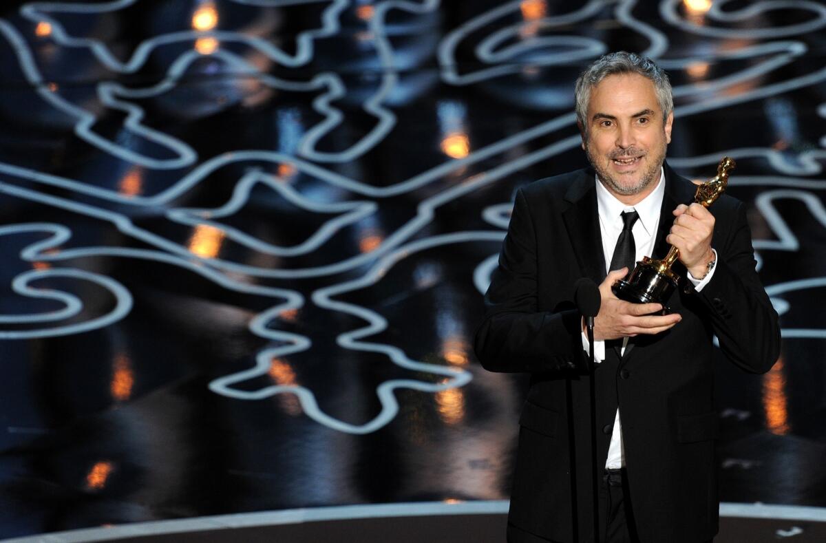 Director Alfonso Cuaron accepts the Oscar for directing 'Gravity.'