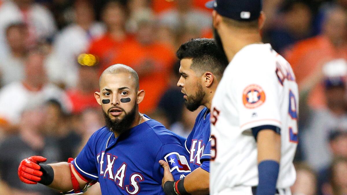 Rangers second baseman Rougned Odor, left, is restrained by a teammate after Astros pitcher Lance McCullers, right, threw a pitch behind Mike Napoli (not pictured) to ignite a benches-clearing melee on May 1.