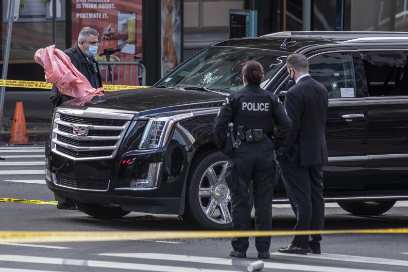 An SUV in the street surrounded by police investigators 
