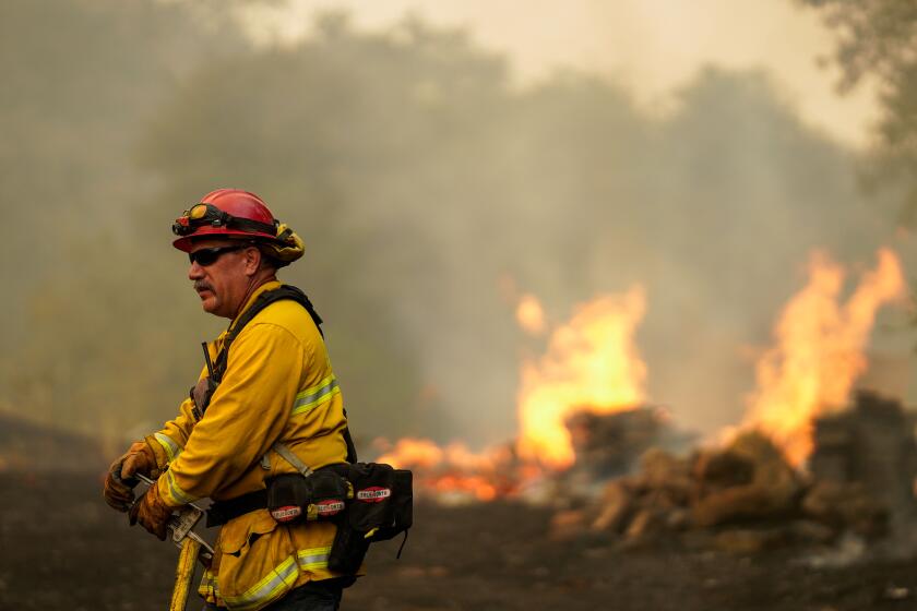 VACAVILLE, CA - AUGUST 19: A firefighter along Solar Hills drive during the Hennessy Fire on Wednesday, Aug. 19, 2020 in Vacaville, CA. (Kent Nishimura / Los Angeles Times)