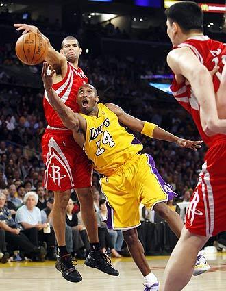 Lakers guard Kobe Bryant flips the ball to the backboard as he makes a circus shot past Rockets forward Shane Battier late in Game 2 of their Western Conference semifinal series at Staples Center.