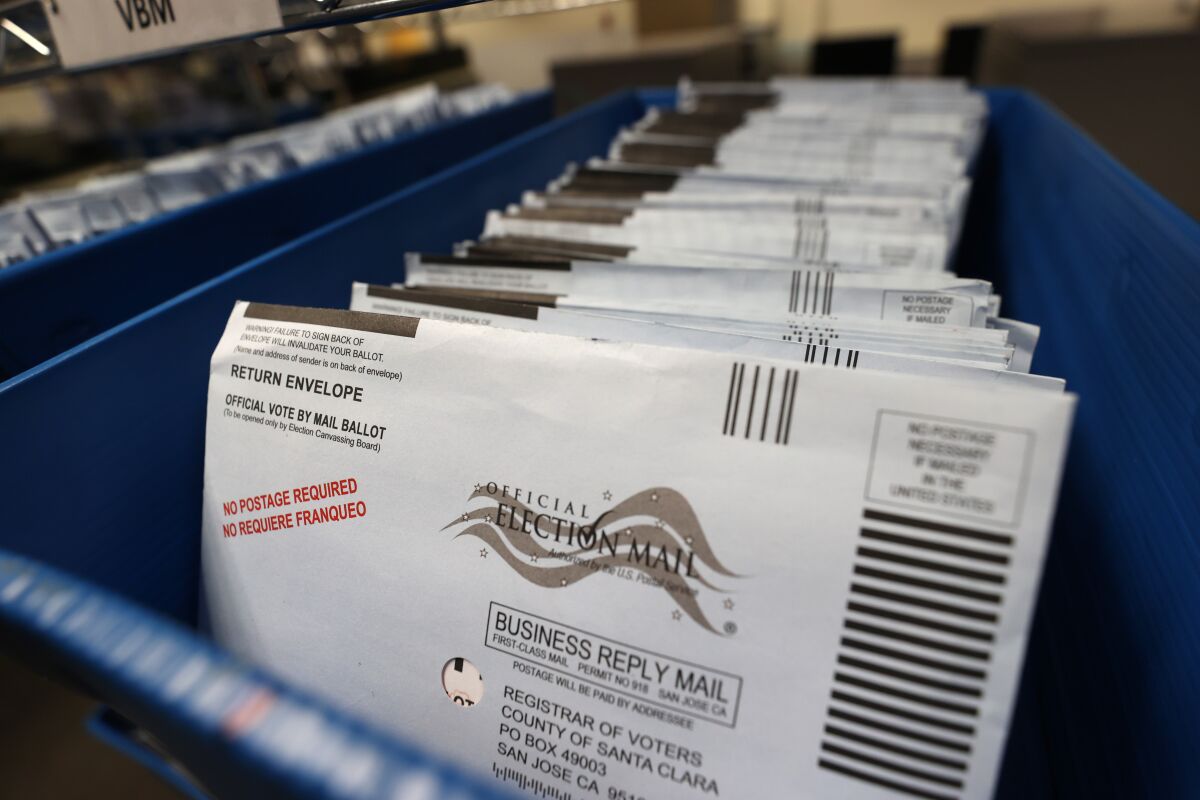 Mail-in ballots sit in trays before being sorted at the Santa Clara County registrar of voters office.