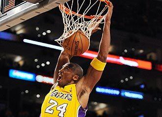 Lakers guard Kobe Bryant finishes off a slam in front of Blazers center Joel Pryzbilla during the fourth quarter Tuesday night.