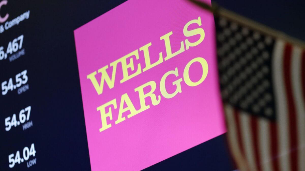 The logo for Wells Fargo appears above a trading post on the floor of the New York Stock Exchange.
