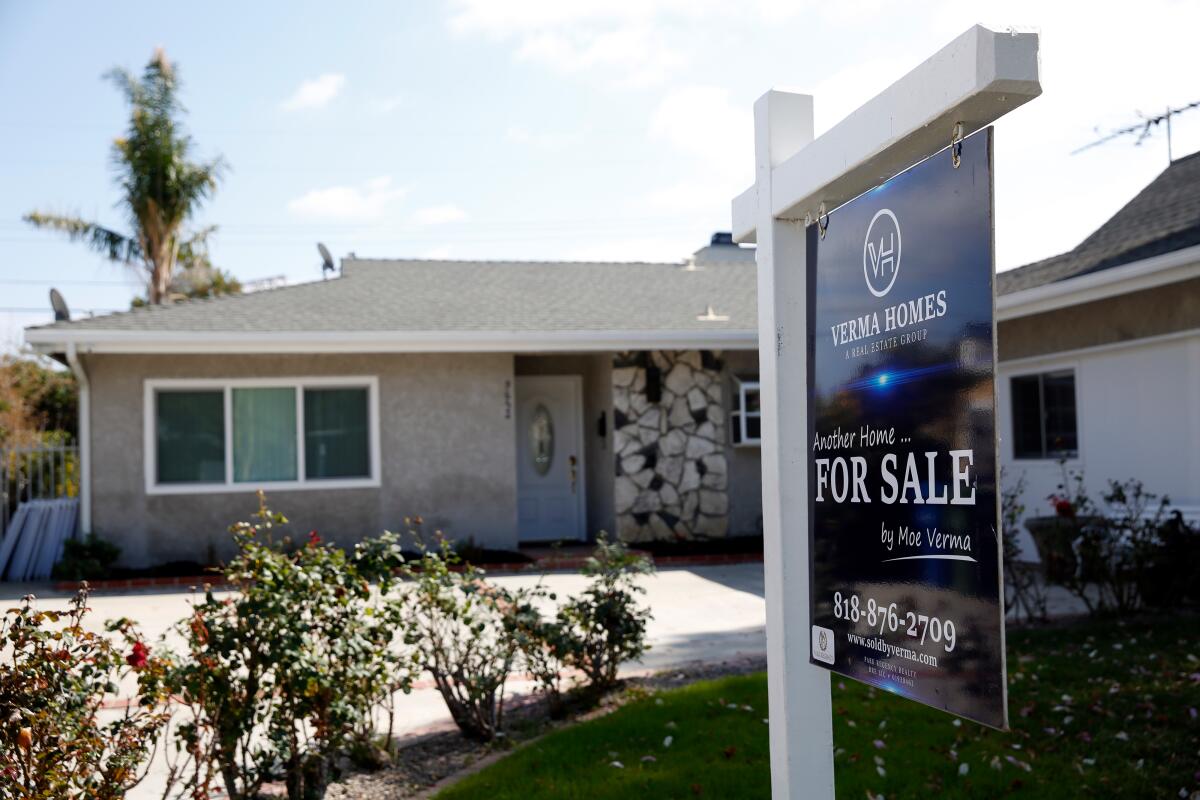 A for sale sign in front of a house.