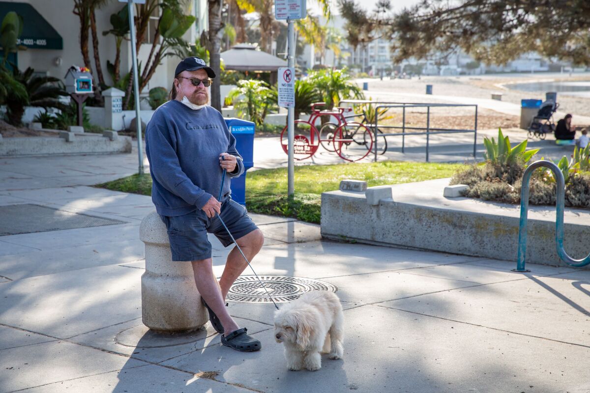 Ray Hamel and Popcorn, a Maltese poodle, take a break at Fanuel Street Park in Pacific Beach.