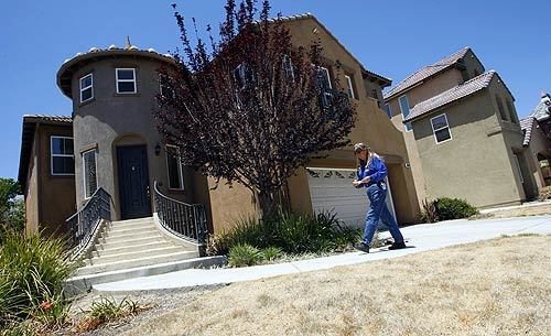Temecula code enforcement officer Jean Voshall prepares to post a violation notice on this vacant house on Kingston Drive. Voshall is part of a team of inspectors who follow up on complaints of code violations such as dead lawns, junk cars and algae-clogged swimming pools that incubate mosquitoes. The goal is to help keep up neighborhood home values and the appearance of houses emptied because of the ongoing mortgage meltdown.