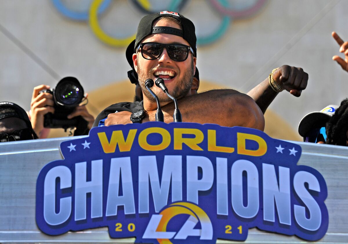 Rams quarterback Matthew Stafford at a lectern with the words "World Champions" and the Rams logo