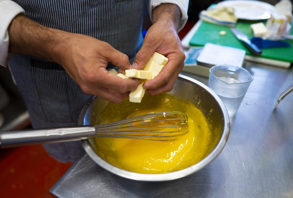 Pieces of cold butter are added to the lemon curd during the mousse preparation.