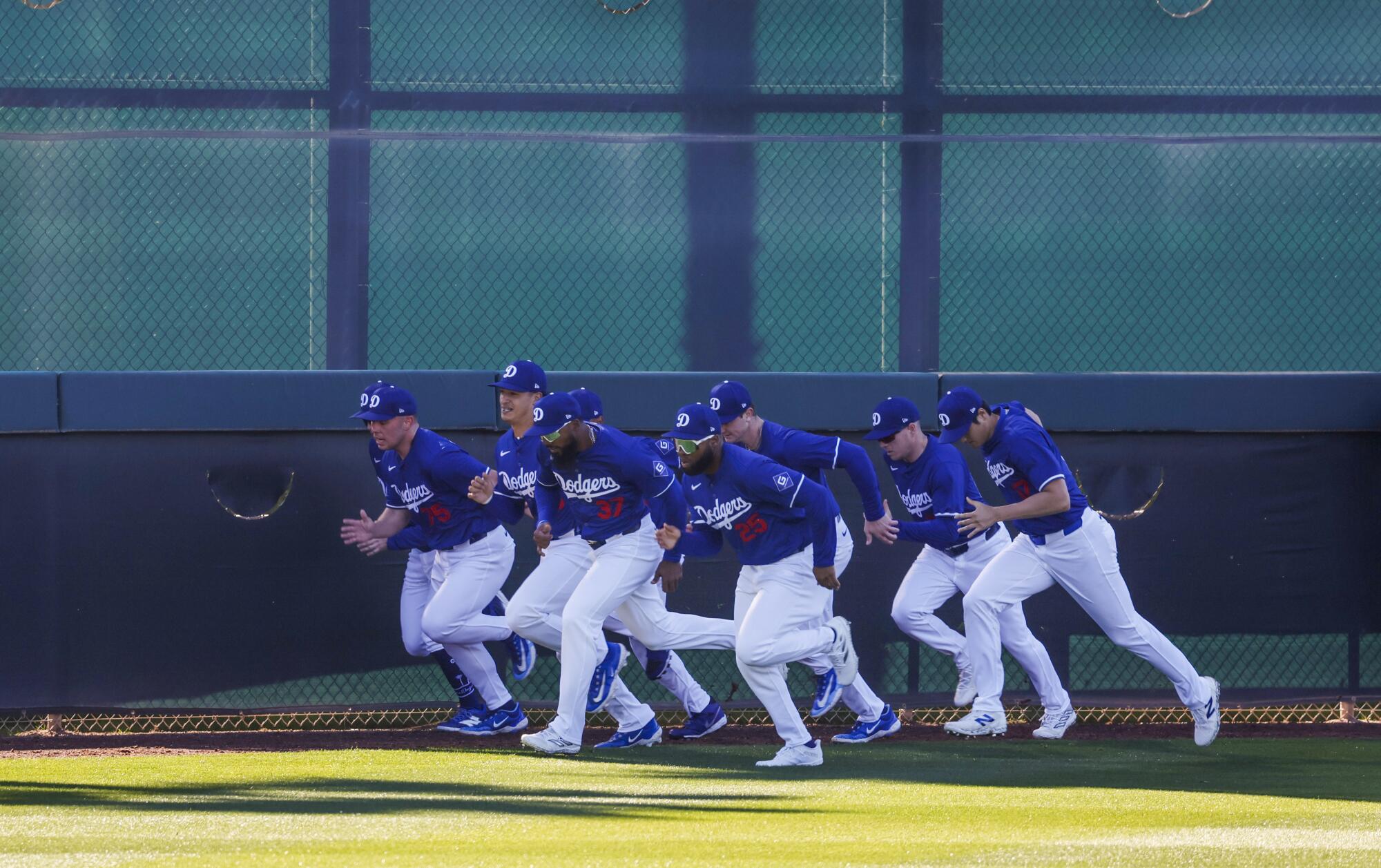 Dodgers players  run sprints in the outfield.