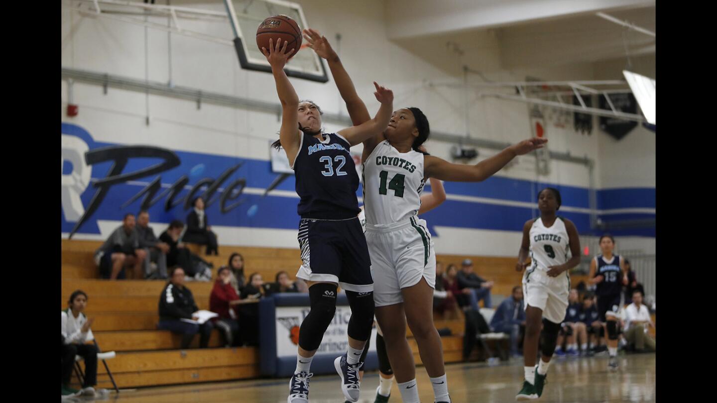 Marina High's Katie Nguyen (32) attacks the basket defended by Buena Park's Donyea Smith (14) during the first half in the Soaring Flight of the Hawk Holiday Classic at Pacifica High on Thursday, December 6, 2018.