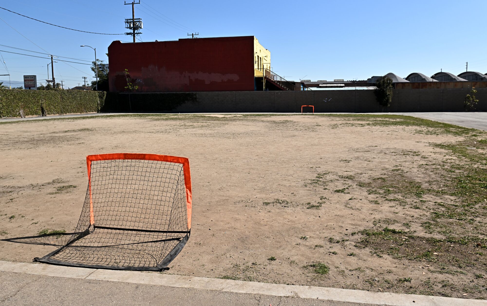 A grass-less, dirt field with soccer goals at each end.