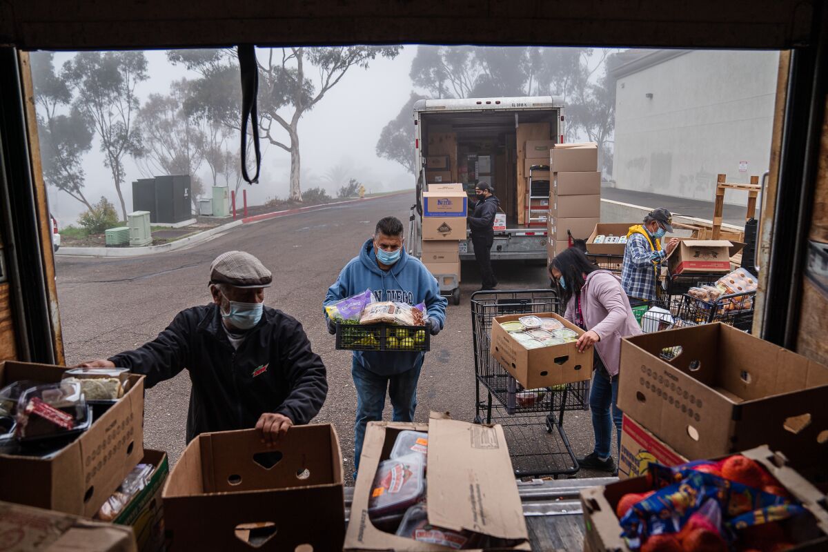 Director of Life Acts Elizabeth Reyes Samala Prado and other volunteersload boxes of food onto a truck at Vons in South Bay 