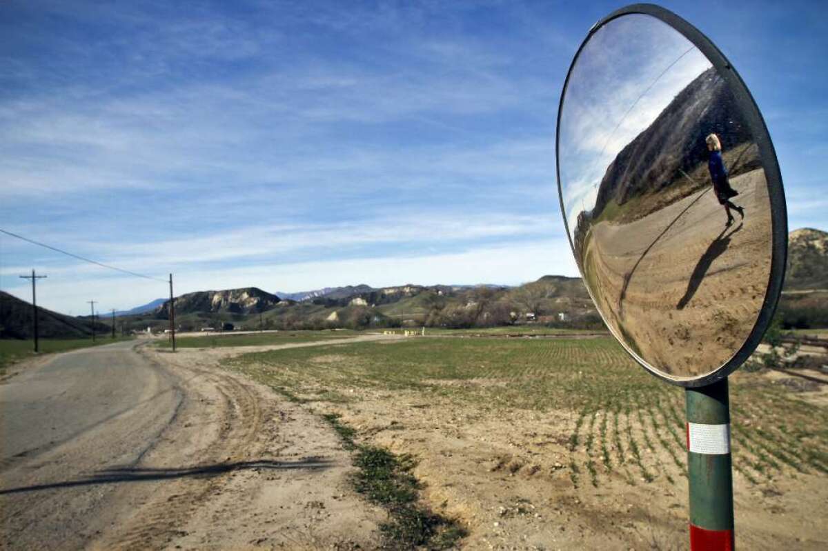 Marlee Lauffer, spokeswoman for Newhall Land and Farming Co., is reflected in a mirror during a tour of Newhall Ranch, the site of a proposed new city 35 miles north of Los Angeles.