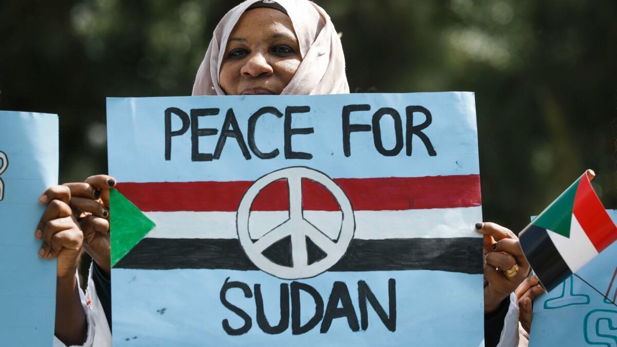 A Sudanese woman looks on with a placard during a protest against Sudan's crackdown on pro-democracy protesters, in Nairobi, Kenya, June 19, 2019.
