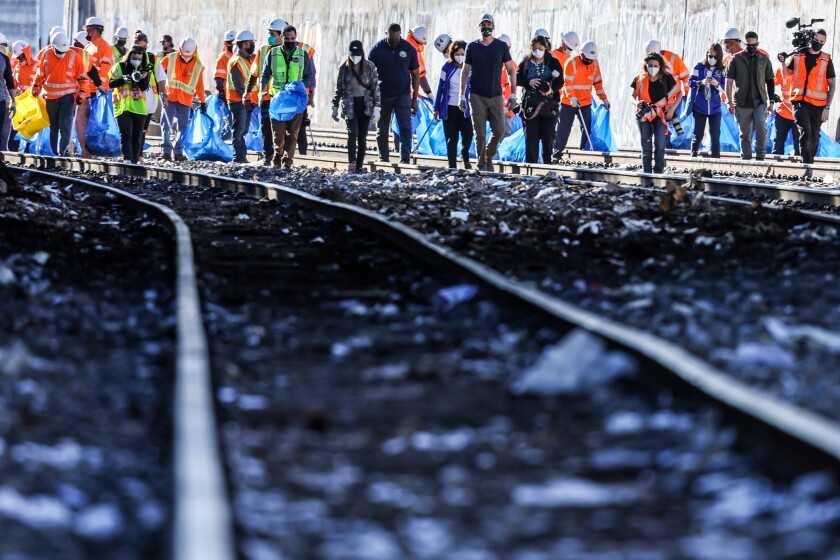 Workers walk along a railroad track.
