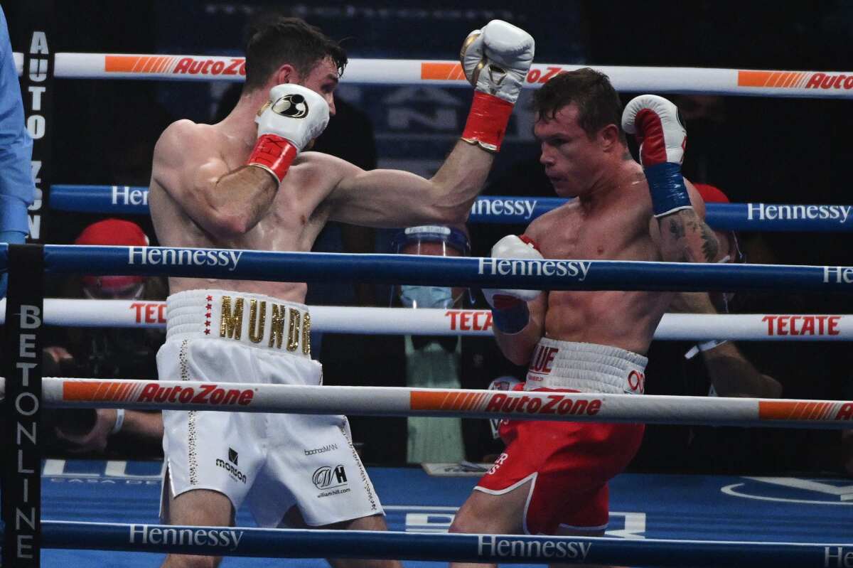 Callum Smith, left, misses Canelo Alvarez with an uppercut throw during their title fight.