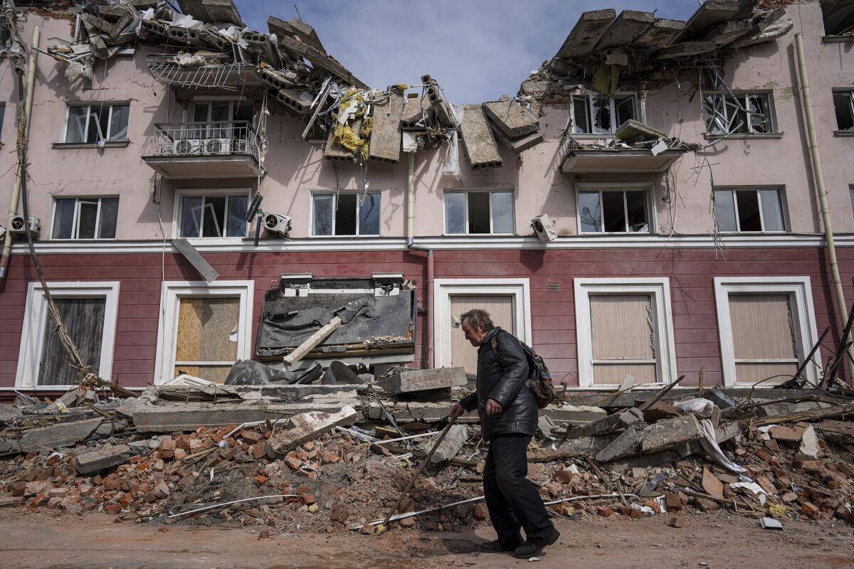A man walks past a building damaged by shelling in Chernihiv, Ukraine.